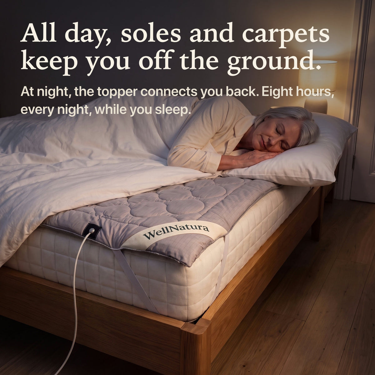 Woman asleep on the grounding topper at night